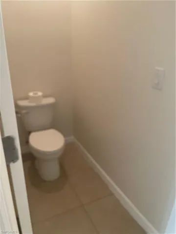 a white toilet sitting next to a white wall