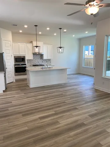 a large kitchen with kitchen island a sink stainless steel appliances and cabinets