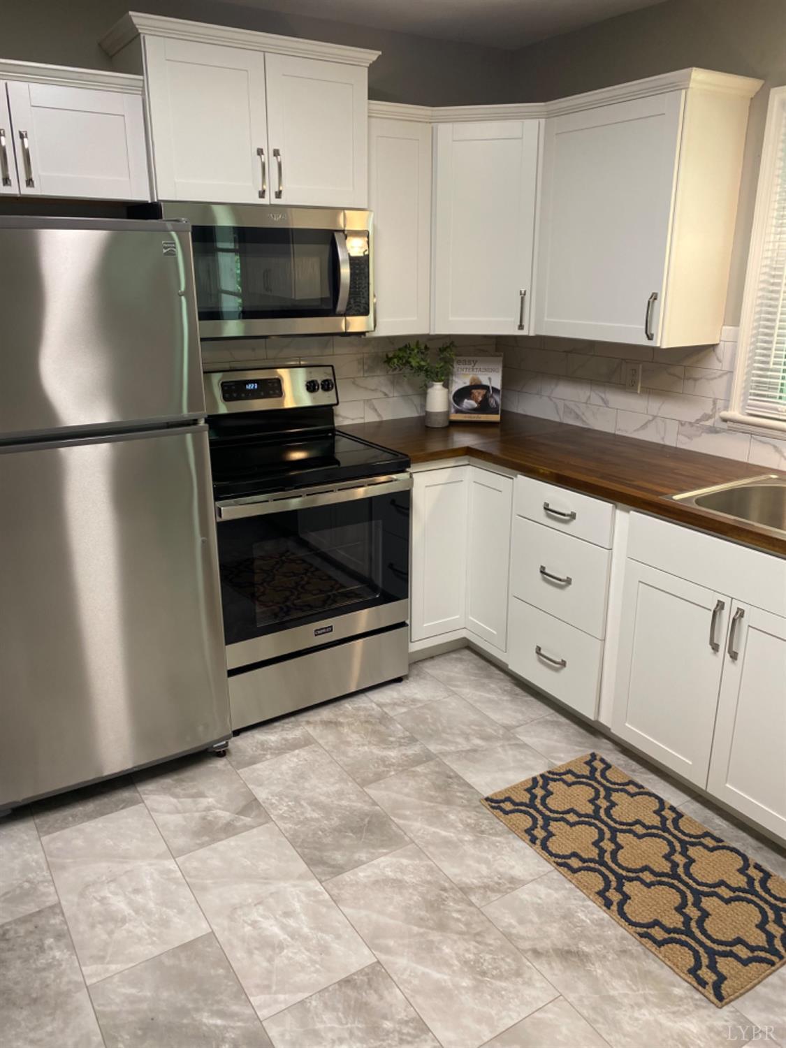 2412 Old Forest Road Lynchburg, VA 24501 - Photo 8 of 29 a kitchen with granite countertop a refrigerator a stove a microwave and cabinets