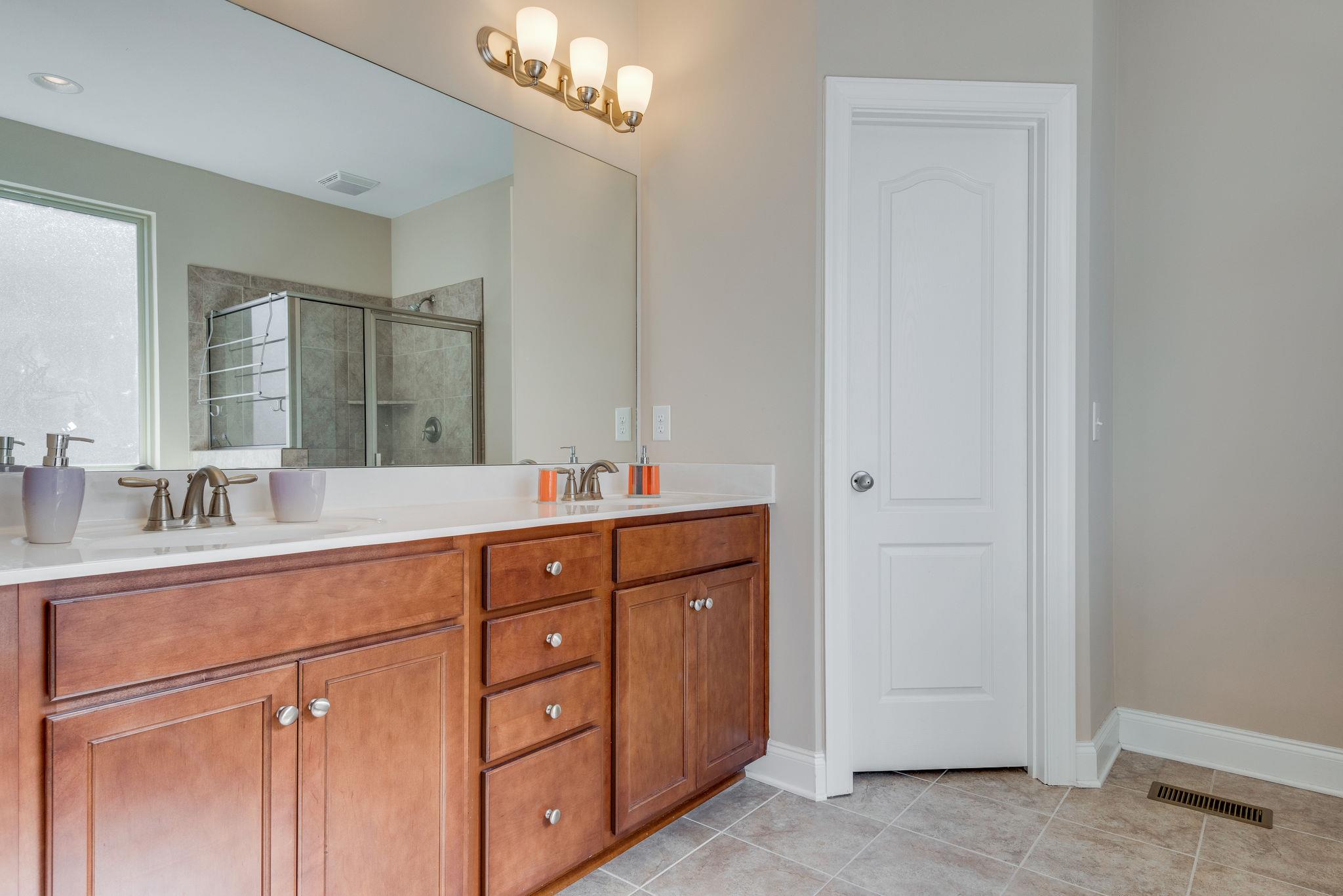 360 Old Stone Road Goodlettsville, TN 37072 - Photo 18 of 28 a bathroom with a granite countertop double vanity sink a mirror and shower