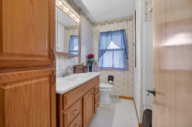 a bathroom with a sink a toilet and shower curtain