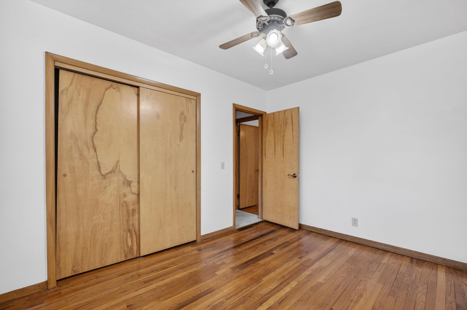 4318 5th Street East Moline, IL 61244 - Photo 19 of 30 a view of an empty room with wooden floor and a ceiling fan