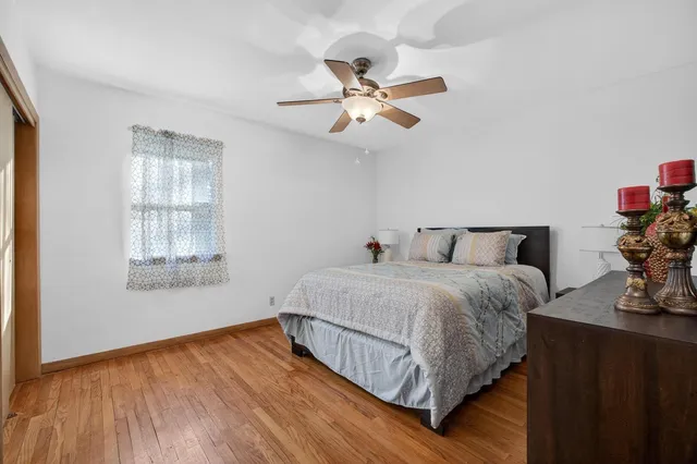 a bedroom with bed and wooden floor
