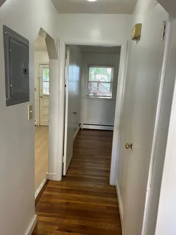 a view of a hallway with wooden floor and staircase