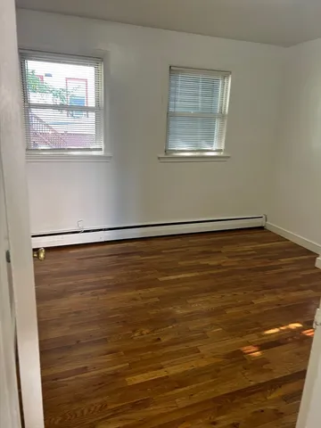 a view of room with window and wooden floor