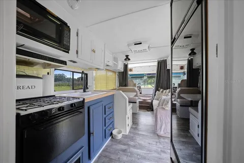 a kitchen with stainless steel appliances kitchen island granite countertop a stove sink and cabinets