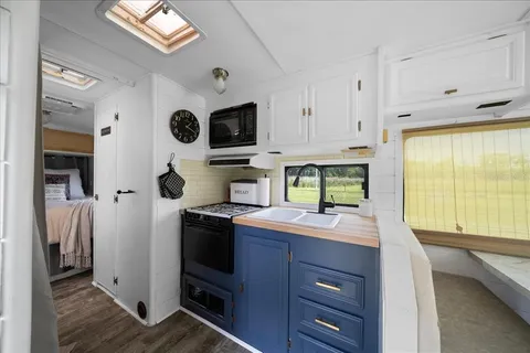 a kitchen with a sink a stove and cabinets