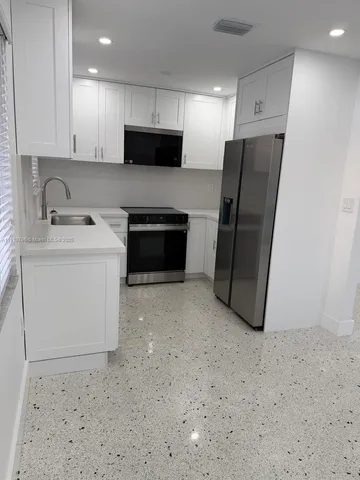 a kitchen with stainless steel appliances a refrigerator stove microwave and sink