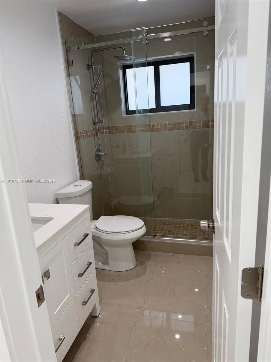 5133 Northwest 4th Street, Unit 1 Miami, FL 33126 - Photo 9 of 11 a bathroom with a toilet and a shower
