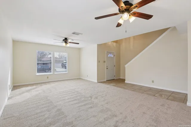 an empty room with fan and windows