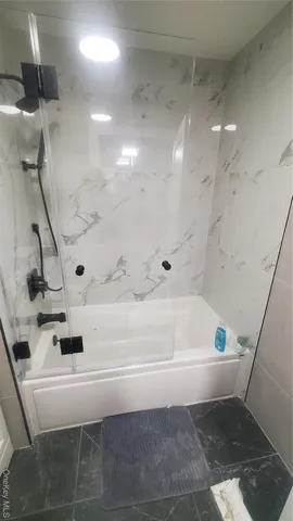 a bathroom with a bathtub and shower