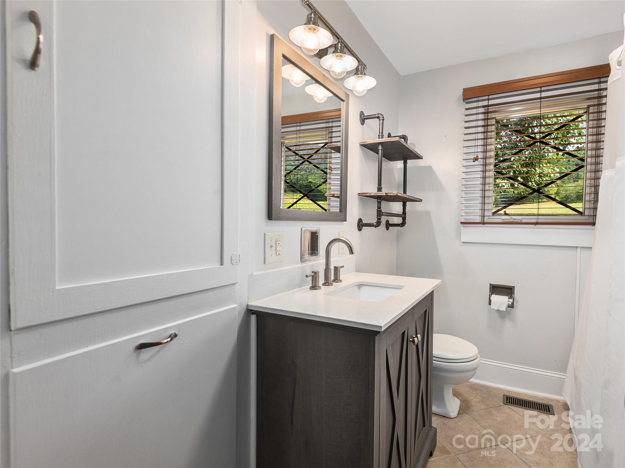2356 Panther Creek Road Clyde, NC 28721 - Photo 19 of 22 a bathroom with a sink a toilet and a window