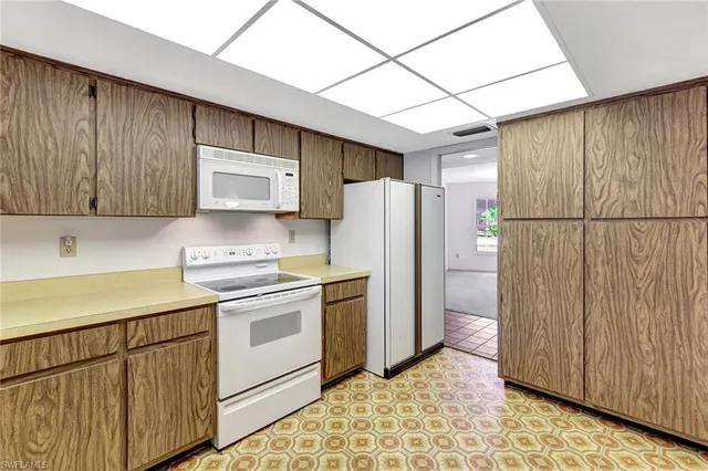 a kitchen with kitchen island granite countertop a sink stove and refrigerator