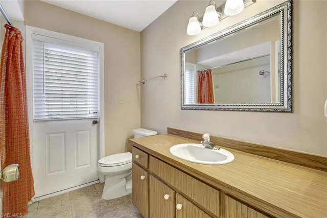 en empty room with windows and chandelier fan