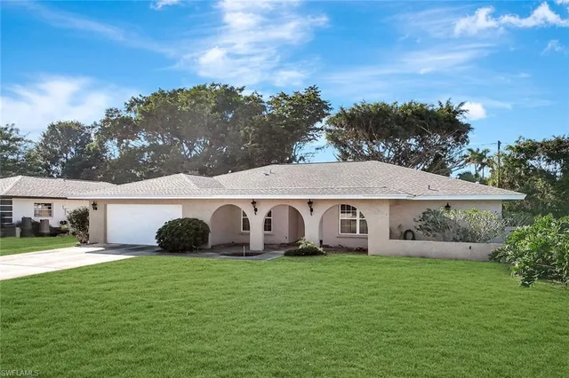 an aerial view of a house with swimming pool and a yard