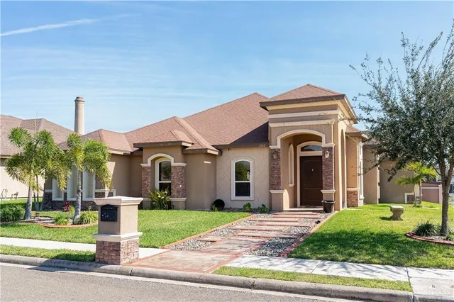 a front view of a house with a garden and plants