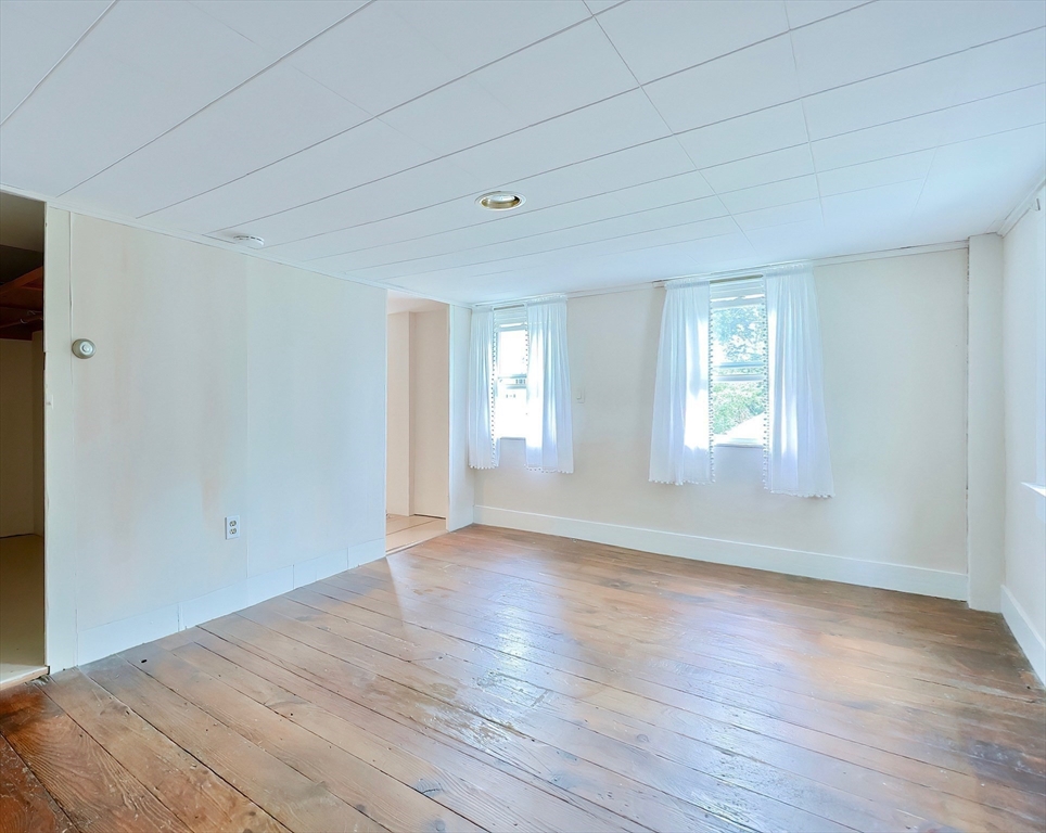 13 Wilson Street Clinton, MA 01510 - Photo 18 of 23 an empty room with wooden floor and windows