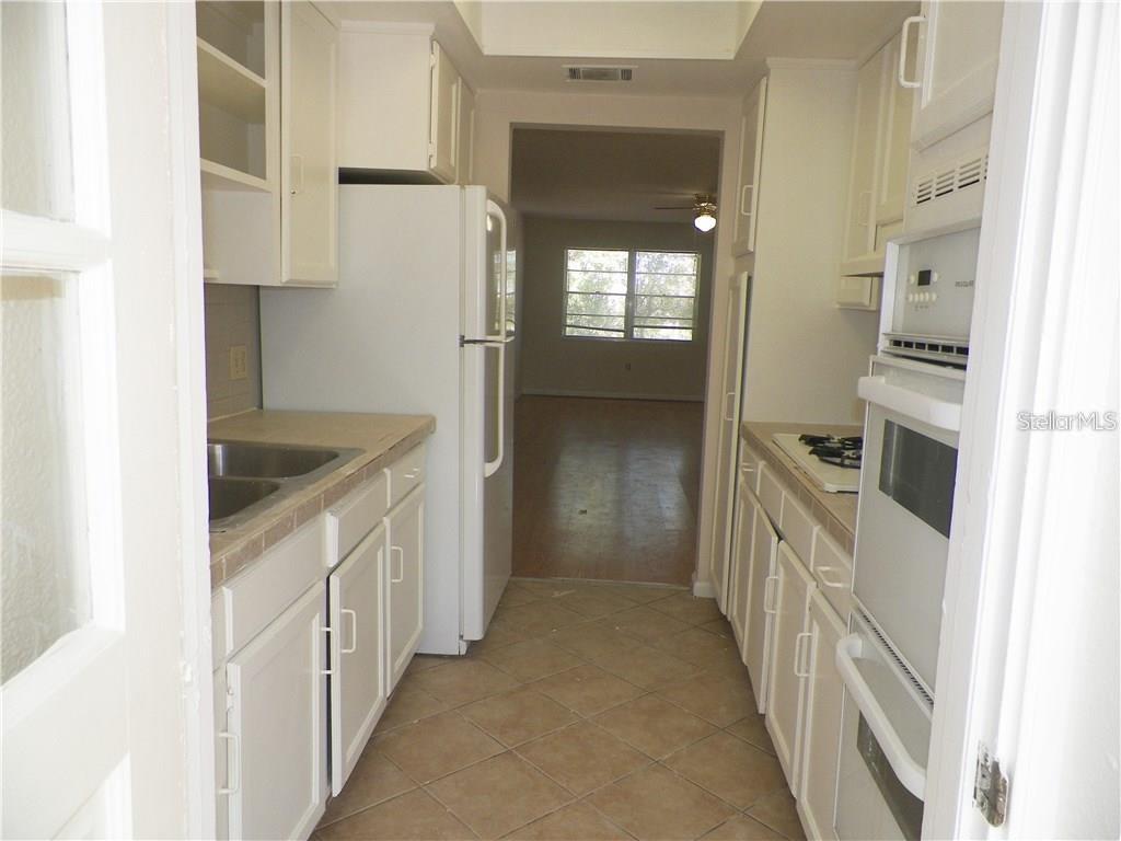 911 Washington Avenue Southwest, Unit 304 Largo, FL 33770 - Photo 10 of 26 a kitchen with a sink and refrigerator