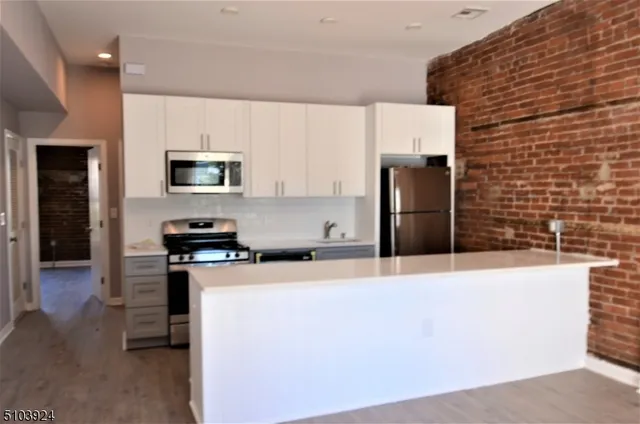 a kitchen with stainless steel appliances a refrigerator a stove top oven a sink and dishwasher