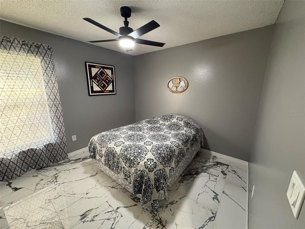 3123 East Marcia Street Inverness, FL 34453 - Photo 12 of 32 a bedroom with a bed and a chandelier