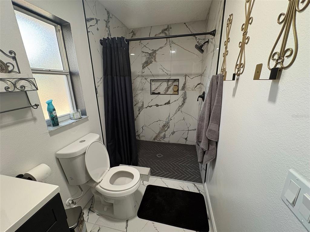 3123 East Marcia Street Inverness, FL 34453 - Photo 15 of 32 a white toilet sitting next to a bathroom sink