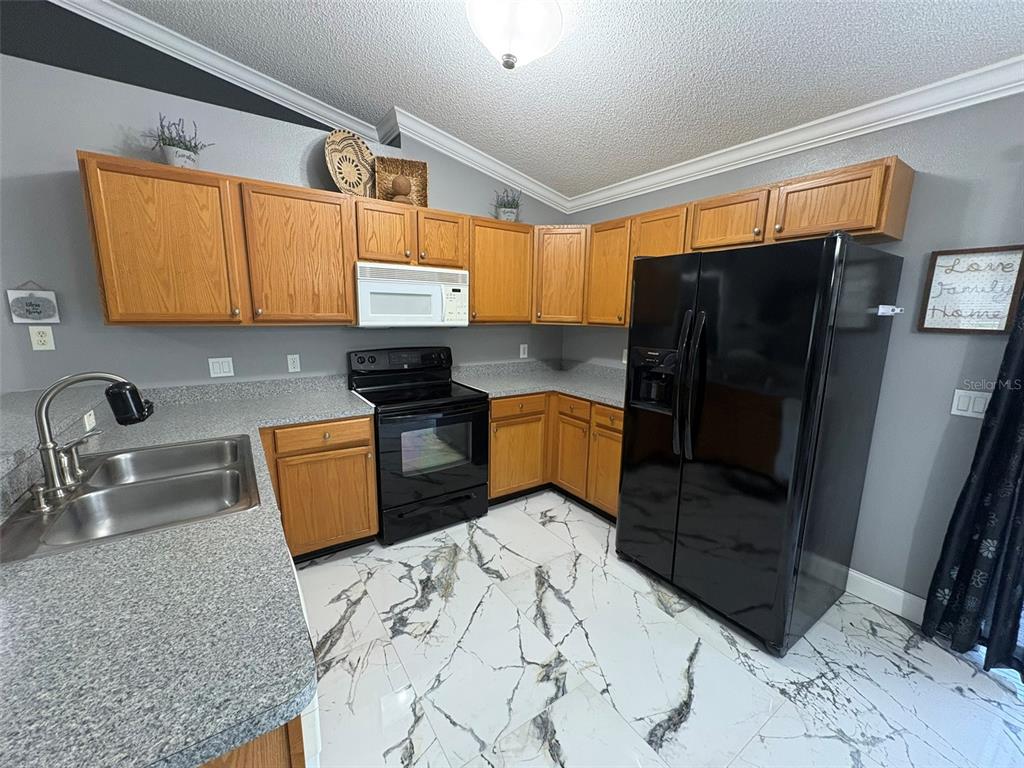 3123 East Marcia Street Inverness, FL 34453 - Photo 5 of 32 a kitchen with stainless steel appliances granite countertop a refrigerator and a sink