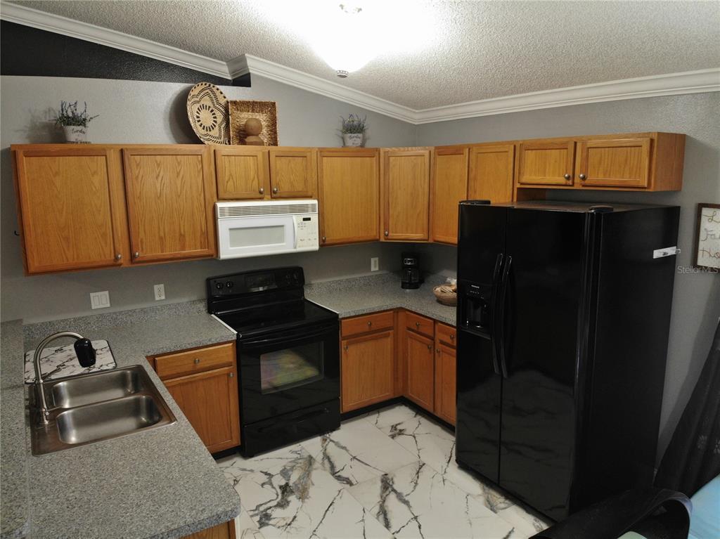3123 East Marcia Street Inverness, FL 34453 - Photo 7 of 32 a kitchen with stainless steel appliances granite countertop a refrigerator and a stove