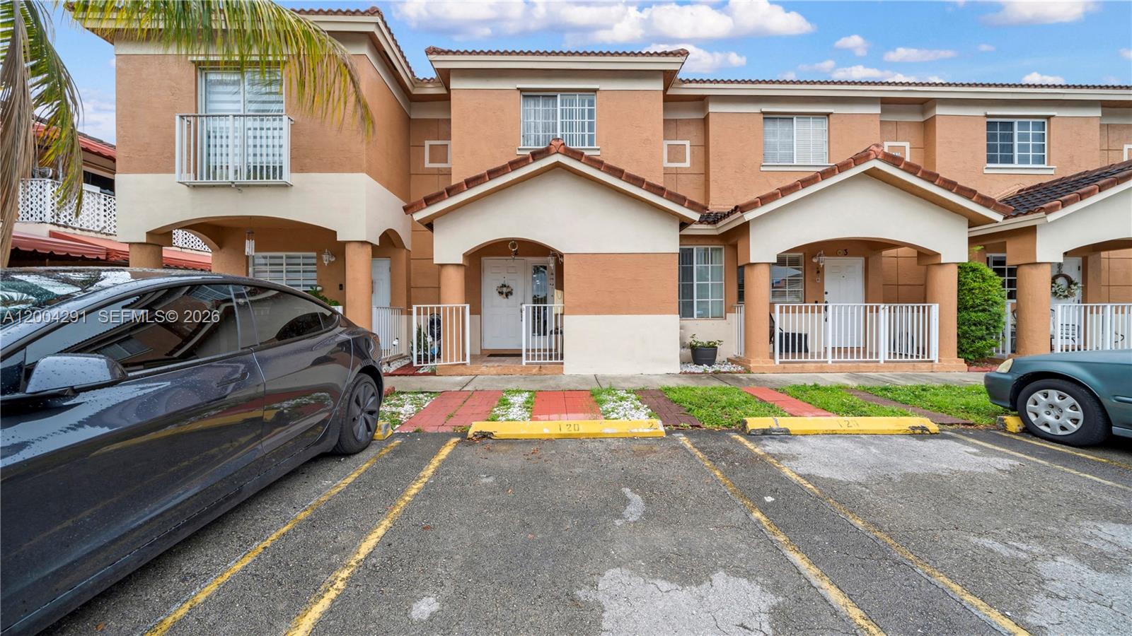 a front view of a house with a yard and parking area