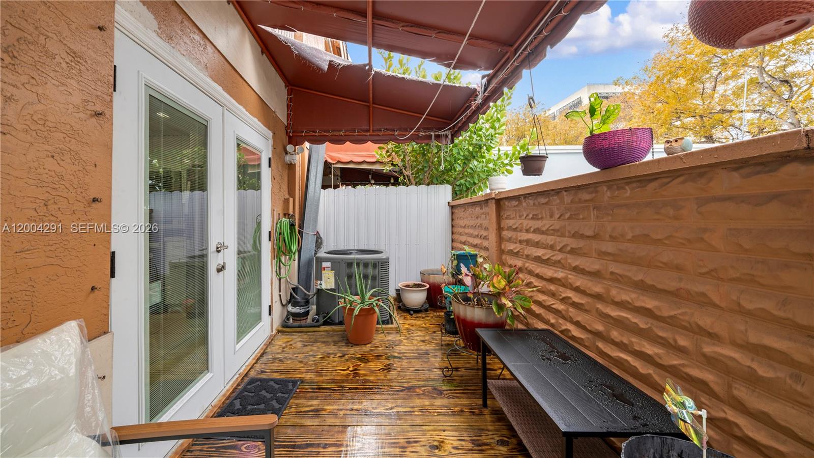 120 East 5th Street, Unit 2 Hialeah, FL 33010 - Photo 21 of 42 a view of a patio with table and chairs potted plants with wooden floor