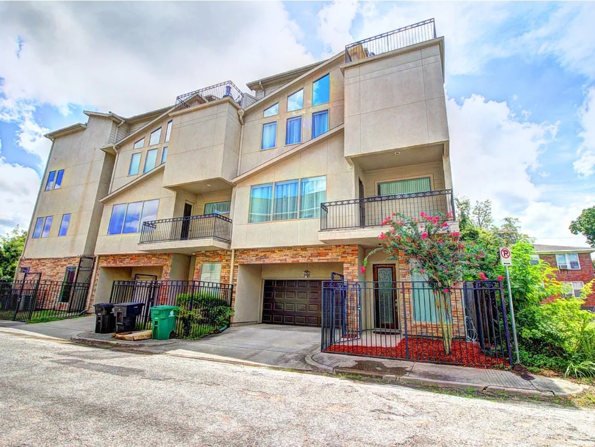 Modern multi-story townhouse showcasing a sleek stucco exterior, expansive windows that fill the home with natural light, and multiple balconies ideal for outdoor living.
