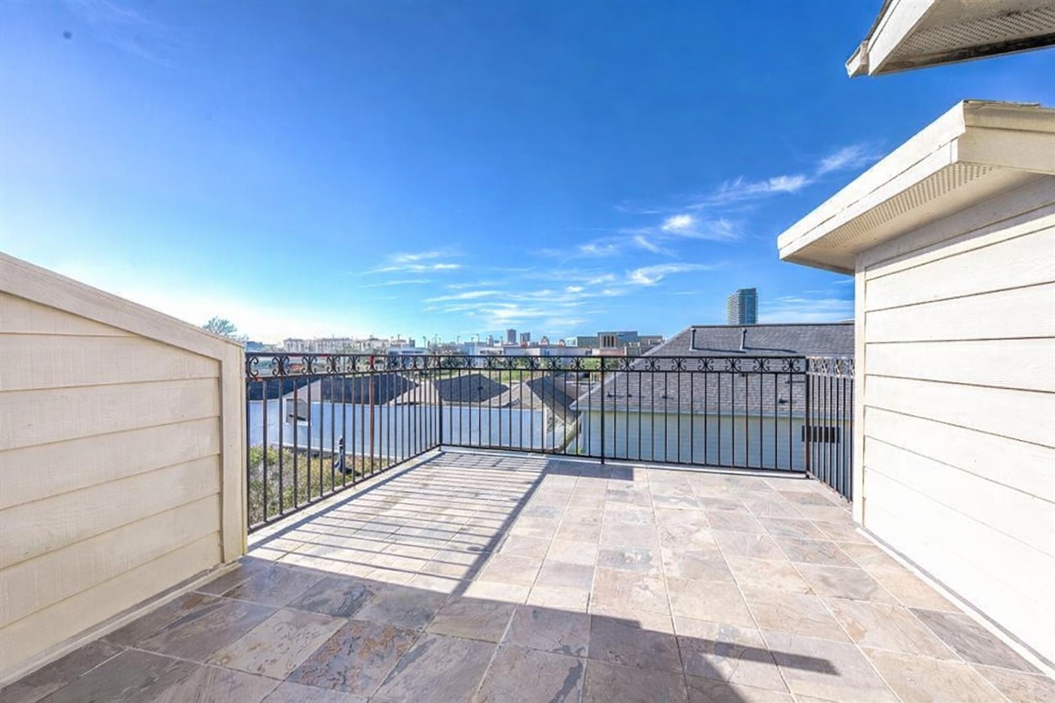 3507 Jackson Street Houston, TX 77004 - Photo 3 of 20 Rooftop terrace with tiled flooring, offering expansive cityscape views under a clear blue sky. Ideal for outdoor relaxation and entertaining.