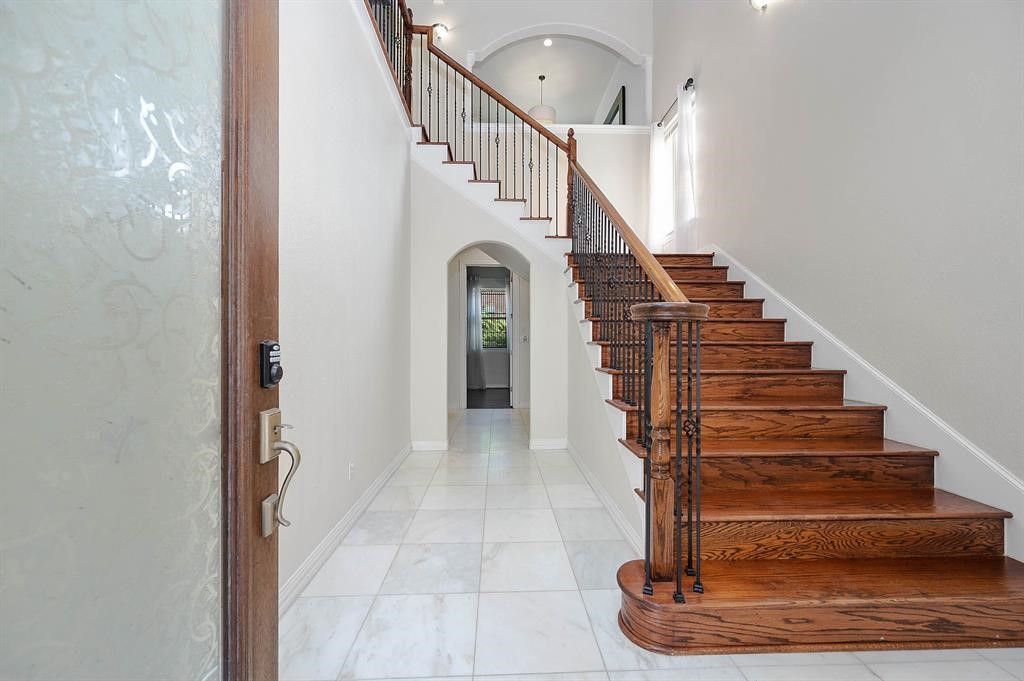 3507 Jackson Street Houston, TX 77004 - Photo 4 of 20 Grand foyer leading to a curved wooden staircase with wrought iron railings, providing an elegant entrance to the home.