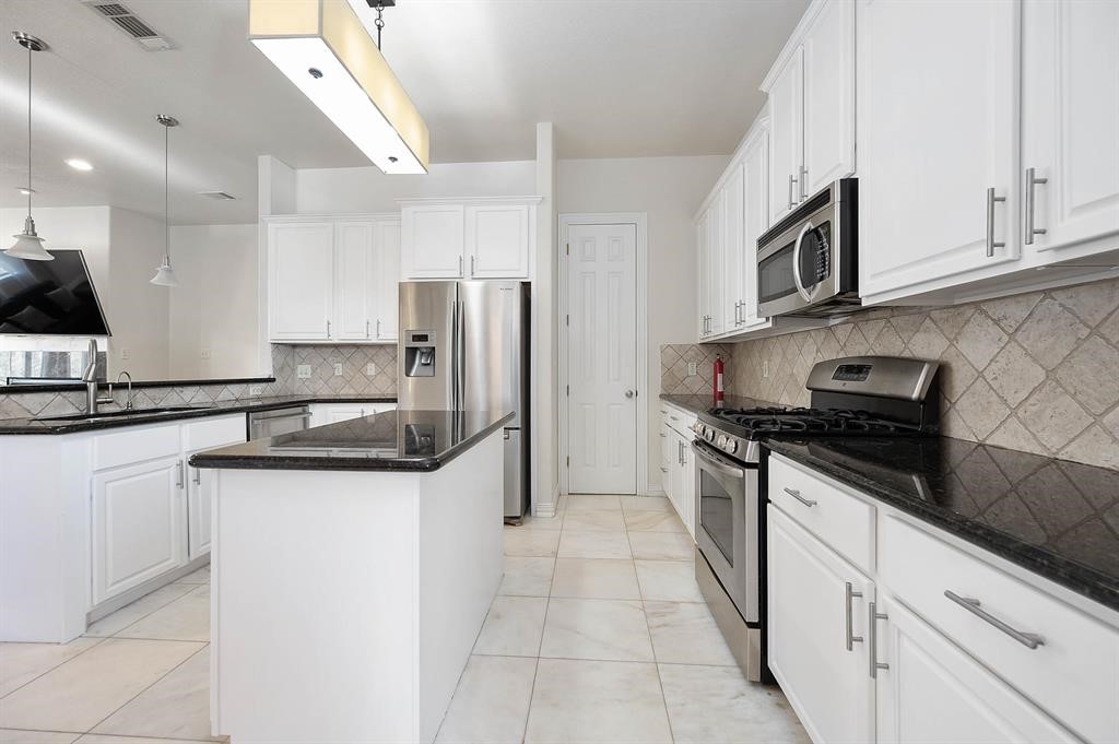3507 Jackson Street Houston, TX 77004 - Photo 7 of 20 Bright, modern kitchen with a large island, ample cabinetry, and stainless-steel appliances, offering the ideal setup for hosting, meal prep, and casual dining.