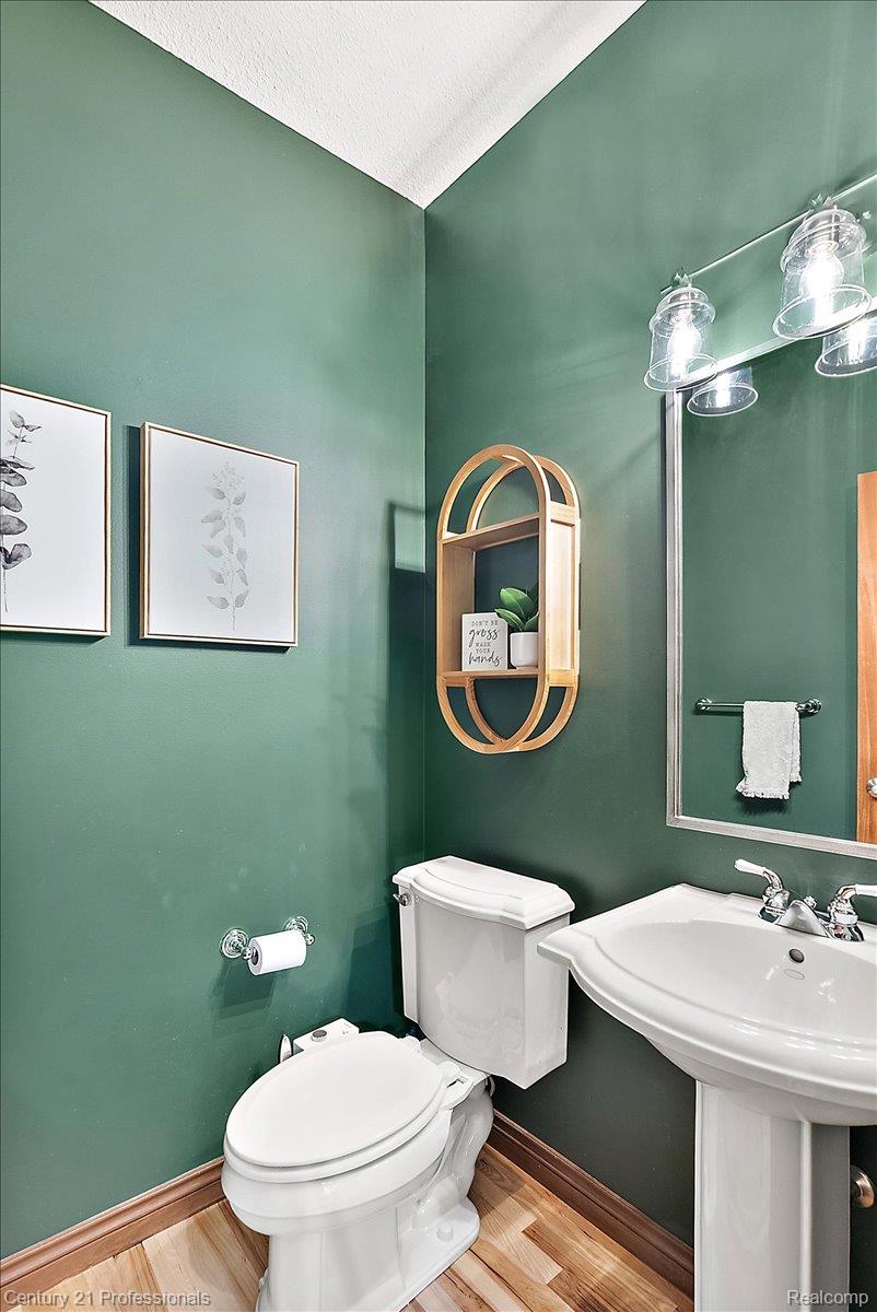 9867 Rainbow Ridge Drive Schoolcraft, MI 49087 - Photo 30 of 82 Pedestal sink with chrome faucet, wood-finish flooring, and green painted walls