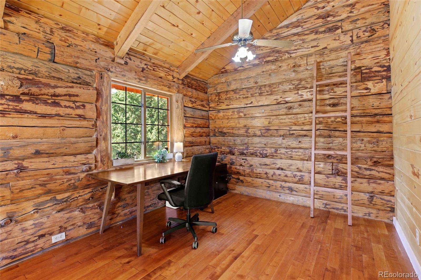 310 Holmes Gulch Road Bailey, CO 80421 - Photo 17 of 48 a view of a workspace with wooden floor and a window