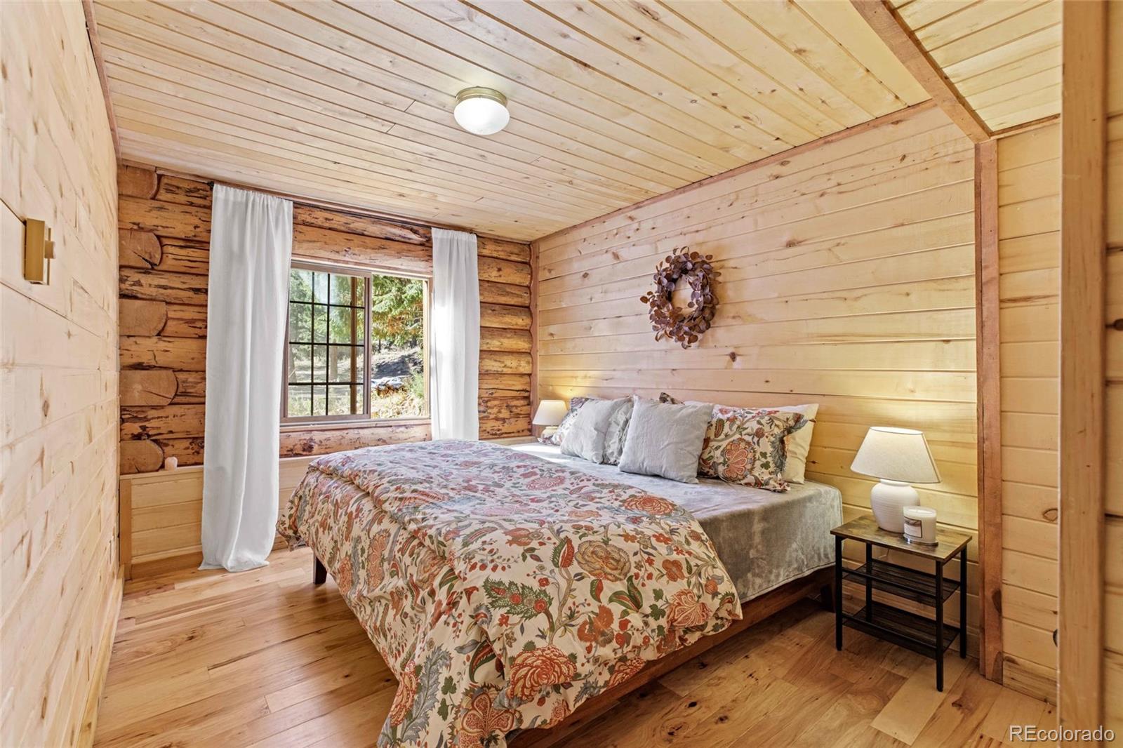 310 Holmes Gulch Road Bailey, CO 80421 - Photo 26 of 48 a bed sitting in a spacious bedroom next to a window