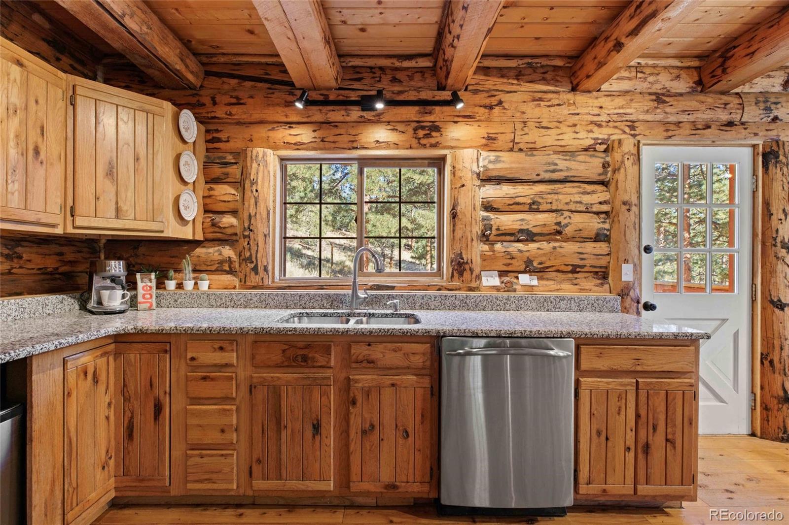 310 Holmes Gulch Road Bailey, CO 80421 - Photo 10 of 48 a kitchen with stainless steel appliances granite countertop wooden cabinets and a counter top space