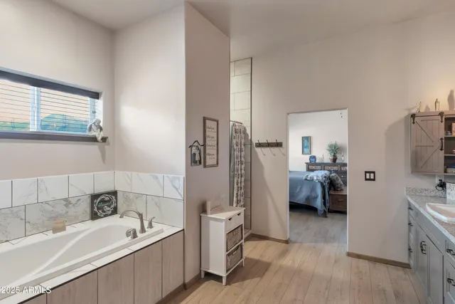 a bathroom with a tub sink and mirror