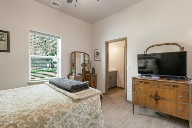 a bedroom with a bed and a flat tv screen on wall