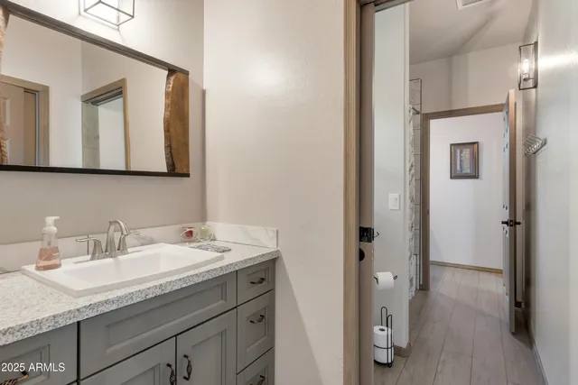 a en suite bathroom with a granite countertop sink and a mirror