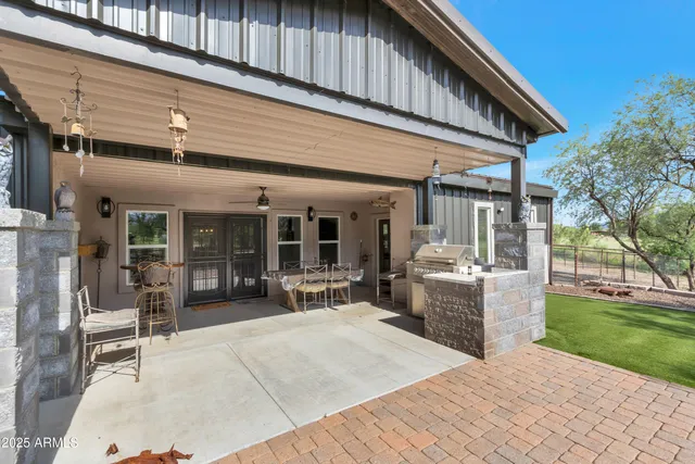 a patio with a table and chairs and potted plants