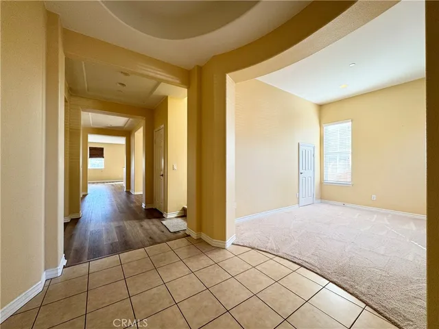 a view of a hallway with wooden floor and closet
