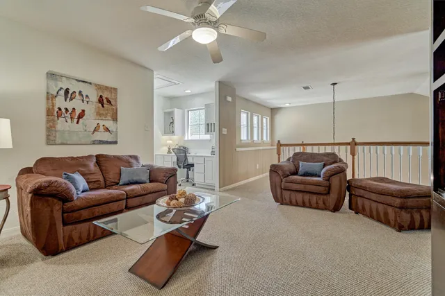 a living room with furniture ceiling fan and a rug