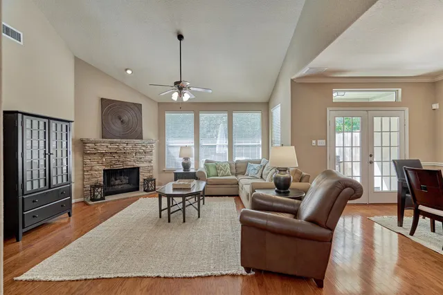 a living room with furniture a fireplace and a floor to ceiling window