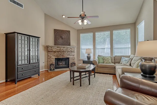 a living room with furniture a fireplace and a large window