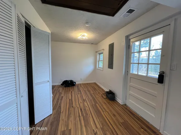 a view of a hallway with wooden floor and a window