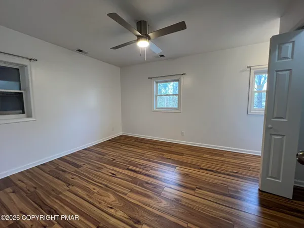 a view of empty room with wooden floor