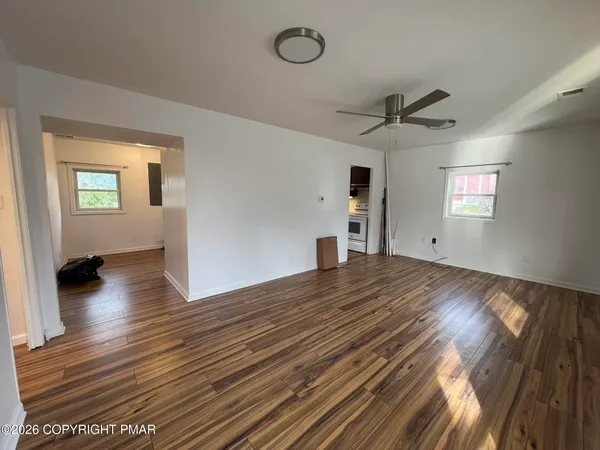 a view of empty room with wooden floor