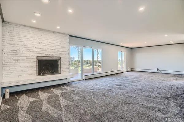 a view of an empty room with a fireplace and a window