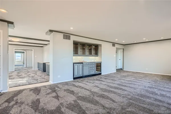 a view of empty room with a kitchen